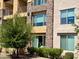 Close up of multi-level apartments with stone accents and lush green landscaping, including a 'For Sale' sign at 4803 N Woodmere Fairway -- # 2006, Scottsdale, AZ 85251