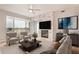 Bright living room with fireplace, ceiling fan, two chairs, and large window with view at 4803 N Woodmere Fairway -- # 2006, Scottsdale, AZ 85251