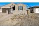 Tan house with brown garage door and small trees at 17738 W Coolidge St, Goodyear, AZ 85395