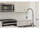 Stainless steel sink and faucet with white cabinets and quartz countertop at 17738 W Coolidge St, Goodyear, AZ 85395