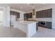 Spacious kitchen with an island, dark cabinets, and quartz counters at 19026 W Ocotillo Rd, Waddell, AZ 85355