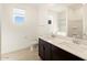 Bathroom featuring double sinks, dark cabinets and a large vanity mirror at 25975 N 160Th Ln, Surprise, AZ 85387