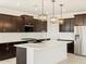 Modern kitchen featuring dark cabinetry, stainless steel appliances, and a spacious island at 25975 N 160Th Ln, Surprise, AZ 85387