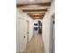 Bright hallway with wood-look tile floors and exposed wood beams at 380 E Fletcher Ln, Wickenburg, AZ 85390