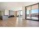 Bright living room with wood floors, fireplace, kitchen island and sliding glass doors to an outdoor patio at 5000 N Camelback Ridge Rd # 201, Scottsdale, AZ 85251