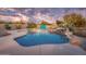 Inviting freeform pool with a waterfall feature, surrounded by desert landscaping at 15339 E Red Bird Rd, Scottsdale, AZ 85262