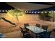 This backyard has a slide, mature trees, and outdoor dining under decorative string lights at 22004 W Moonlight Path, Buckeye, AZ 85326