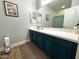 Well-lit bathroom featuring a long vanity with teal cabinets, a bright white countertop and updated fixtures at 22004 W Moonlight Path, Buckeye, AZ 85326