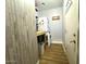Functional laundry room with stacked washer/dryer, wood-look floors, and door leading to another room at 22004 W Moonlight Path, Buckeye, AZ 85326