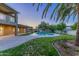 A serene backyard with a sparkling pool, lush lawn, mature trees, and a covered patio at 10647 N 82Nd Pl, Scottsdale, AZ 85260