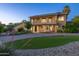 A beautifully landscaped two-story home with a charming balcony and well-manicured lawn at 10647 N 82Nd Pl, Scottsdale, AZ 85260