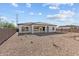 Spacious backyard with desert landscape featuring a covered patio with stone columns at 12308 W Parkway Ln, Avondale, AZ 85323