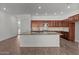 Spacious kitchen features wood cabinets, tile backsplash, granite counters, stainless appliances, and a center island at 12308 W Parkway Ln, Avondale, AZ 85323