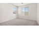 Bright bedroom featuring neutral carpet, white walls, and natural light from two view-framing windows at 18746 E Panchito Dr, Gold Canyon, AZ 85118
