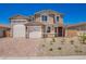 Charming two-story home with a three-car garage, desert landscaping, and a brick paver driveway at 18746 E Panchito Dr, Gold Canyon, AZ 85118