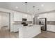 Bright kitchen with white cabinets, stainless steel appliances, a large island, and sleek gray backsplash at 18746 E Panchito Dr, Gold Canyon, AZ 85118