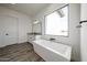 Modern bathroom showcasing a freestanding tub and a large window overlooking the yard at 3295 W Mesquite St, Phoenix, AZ 85086