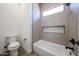 Bathroom featuring a soaking tub with tiled surround and a window providing natural light at 3295 W Mesquite St, Phoenix, AZ 85086