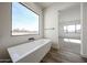 Bright bathroom showcasing a freestanding tub and a large window overlooking the yard at 3295 W Mesquite St, Phoenix, AZ 85086