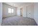 A bedroom with neutral carpet and a window provides natural light at 3295 W Mesquite St, Phoenix, AZ 85086