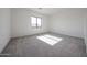 Bedroom with natural lighting, gray carpet, and an exterior view through the black framed window at 3295 W Mesquite St, Phoenix, AZ 85086