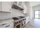 Gourmet kitchen features a stainless steel range hood, Wolf stove, white cabinets, and tile backsplash at 3295 W Mesquite St, Phoenix, AZ 85086