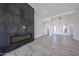 Living area with a fireplace and wood-look flooring leading to a modern entry with bright white walls at 3295 W Mesquite St, Phoenix, AZ 85086