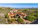 Expansive aerial view showcases a luxurious home with a red tile roof, set amidst lush desert scenery at 42383 N 111Th Pl, Scottsdale, AZ 85262