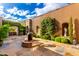 Beautiful courtyard featuring a fire pit, lush greenery, and stone paving, perfect for outdoor relaxation at 42383 N 111Th Pl, Scottsdale, AZ 85262
