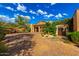 Inviting exterior with a stone driveway, landscaped gardens, and charming architectural details, creating a welcoming entrance at 42383 N 111Th Pl, Scottsdale, AZ 85262