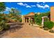 Inviting exterior with a stone driveway, landscaped gardens, and charming architectural details, creating a welcoming entrance at 42383 N 111Th Pl, Scottsdale, AZ 85262