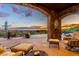 A covered patio provides seating with sunset views, creating a relaxing outdoor space by the pool at 42383 N 111Th Pl, Scottsdale, AZ 85262