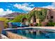 Inviting pool area with comfortable lounge seating, surrounded by lush landscaping and mountain views at 42383 N 111Th Pl, Scottsdale, AZ 85262