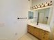 Bathroom vanity with a mirror, a towel rack, and drawers and cabinets for storage at 9744 N 97Th Ln, Peoria, AZ 85345