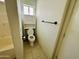 A bathroom features a toilet next to a cabinet and tile floors at 9744 N 97Th Ln, Peoria, AZ 85345