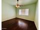 Bright bedroom featuring a ceiling fan, light green walls, and rich dark wood floors at 9744 N 97Th Ln, Peoria, AZ 85345