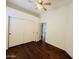 A bedroom with dark wood floors and a closet with sliding doors at 9744 N 97Th Ln, Peoria, AZ 85345