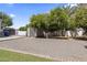 Spacious backyard featuring gravel, a storage shed, mature trees, and ample open space for activities at 2222 N Val Vista Dr # 3, Mesa, AZ 85213