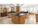 Gourmet kitchen with custom wood cabinets, dark countertops, a central island, and open layout at 2222 N Val Vista Dr # 3, Mesa, AZ 85213