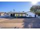 Updated mid-century modern home with a fresh white exterior, landscaping, and a long driveway at 3155 W Augusta Ave, Phoenix, AZ 85051