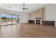 Open-concept living room with stone fireplace, wood-look tile flooring, and scenic backyard views at 13653 E Aloe Vera Dr, Scottsdale, AZ 85262