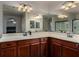 This bathroom features double sinks with granite countertops and a very large mirror on the wall at 955 S Henry Ln, Gilbert, AZ 85296
