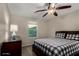 Cozy bedroom features a checkered comforter, ceiling fan and dresser, illuminated by natural light through the window at 955 S Henry Ln, Gilbert, AZ 85296