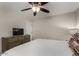 Well-lit bedroom with a modern ceiling fan, dresser, and television, offering a comfortable retreat at 955 S Henry Ln, Gilbert, AZ 85296