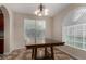 Inviting dining area with an archway, a wooden table, stylish chandelier and natural light from windows at 955 S Henry Ln, Gilbert, AZ 85296