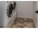 Bright laundry room featuring a white washer and modern flooring at 955 S Henry Ln, Gilbert, AZ 85296