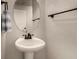 Stylish powder room featuring a pedestal sink, oval mirror, and modern fixtures at 955 S Henry Ln, Gilbert, AZ 85296