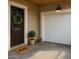 Inviting front entry with a dark door, wreath, charming hello doormat, and a white garage door at 1859 N Morris --, Mesa, AZ 85201