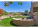 Lush backyard with green grass, desert plants, scenic mountain views, and built-in fire pit at 10646 E Butherus Dr, Scottsdale, AZ 85255