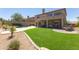 Well-manicured backyard features a synthetic lawn, a dining space, and a small desert garden at 10646 E Butherus Dr, Scottsdale, AZ 85255